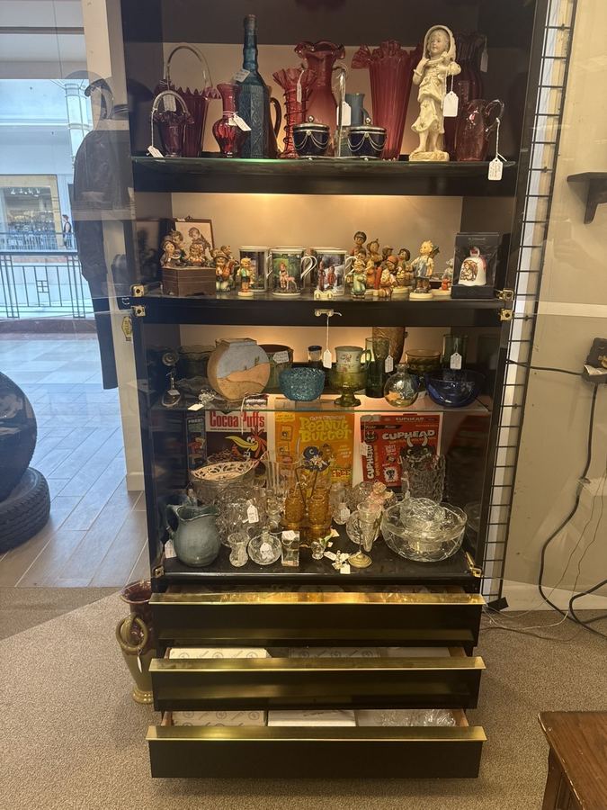 Display case of vintage colored glassware, figurines and collectibles