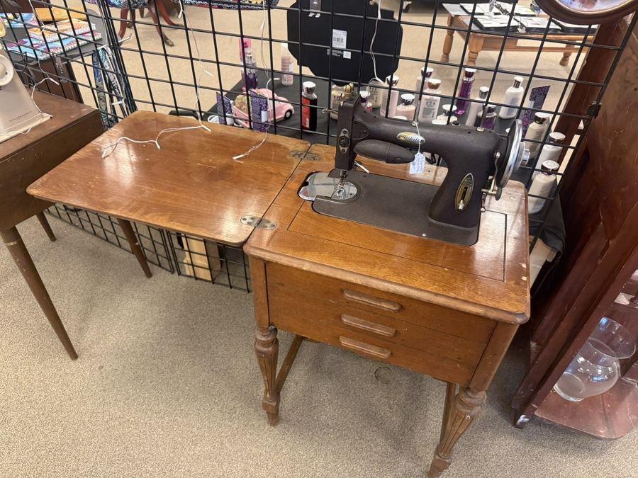 Antique sewing machine in a wooden cabinet